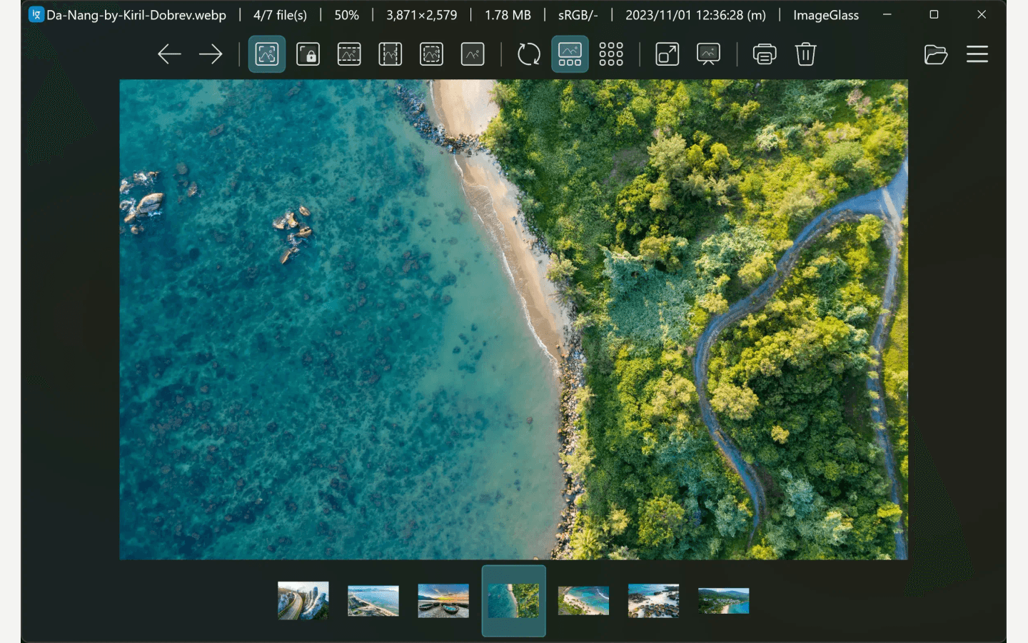 ImageGlass 9.0 官方深色界面截图，中央显示海岸图片，顶部为查看工具栏，底部为缩略图带